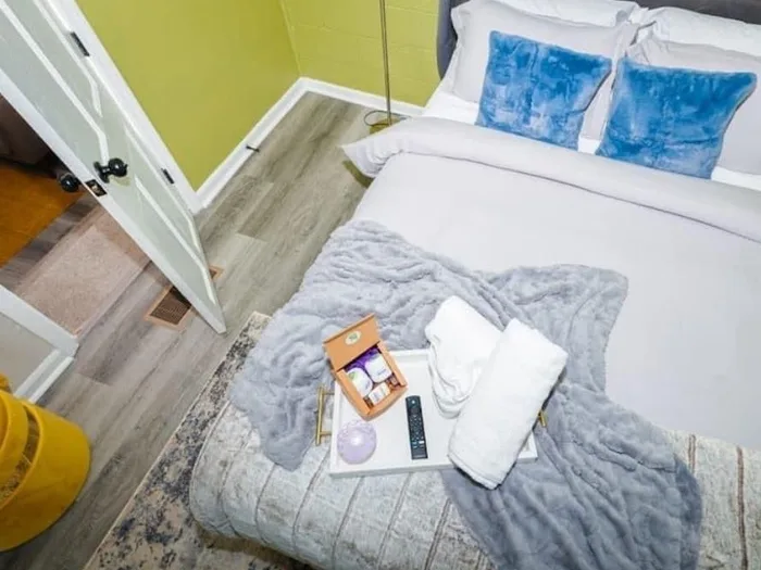 Overhead view of a made bed with fresh towels and amenity tray